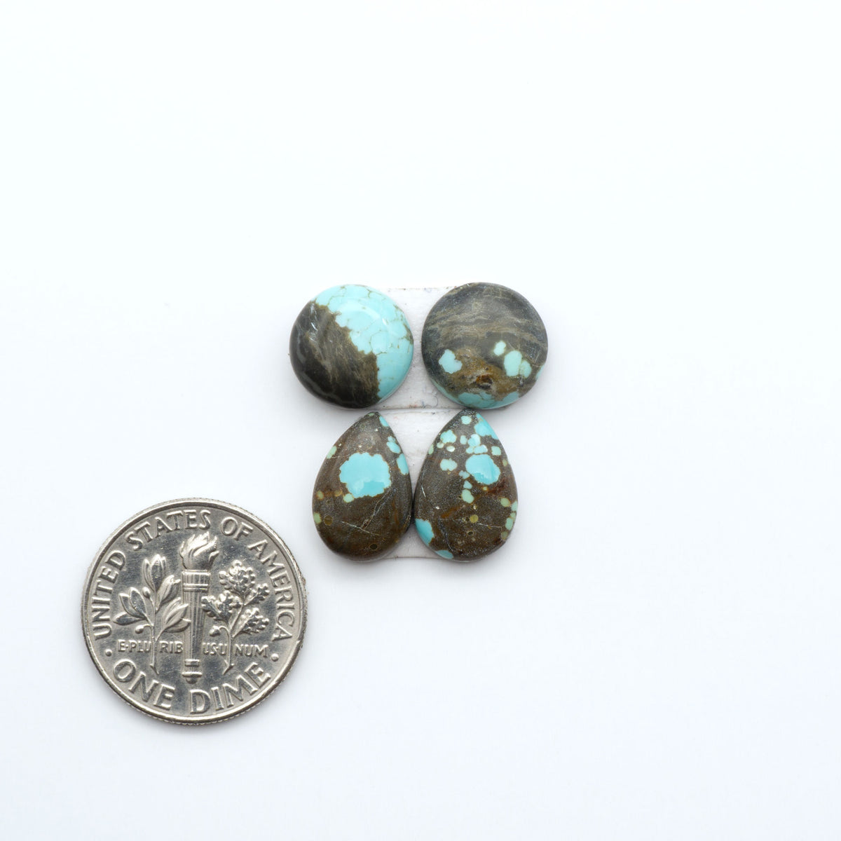 Number 8 Turquoise cabochons, blue and green color with brown matrix, polished stones on a white background, with a US dime for scale