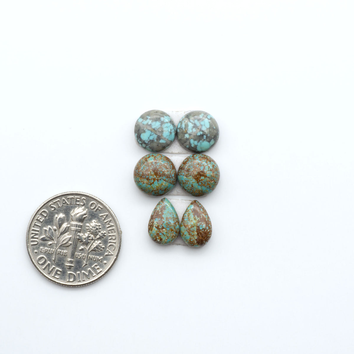 Number 8 Turquoise cabochons, blue and green color with brown matrix, polished stones on a white background, with a US dime for scale