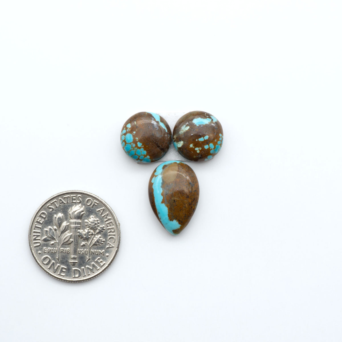 Number 8 Turquoise cabochons, blue and green color with brown matrix, polished stones on a white background, with a US dime for scale