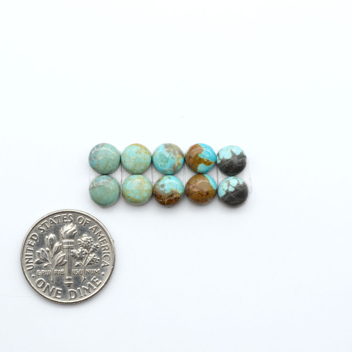 Number 8 Turquoise cabochons, blue and green color with brown matrix, polished stones on a white background, with a US dime for scale