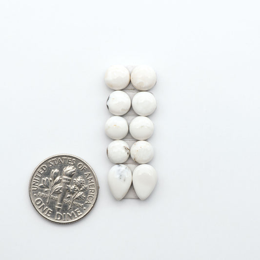 White Buffalo stone cabochons, white stone with black matrix, polished stones on a white background, with a US dime for scale