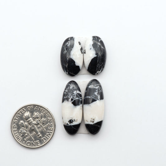 White Buffalo stone cabochons, white stone with black matrix, polished stones on a white background, with a US dime for scale