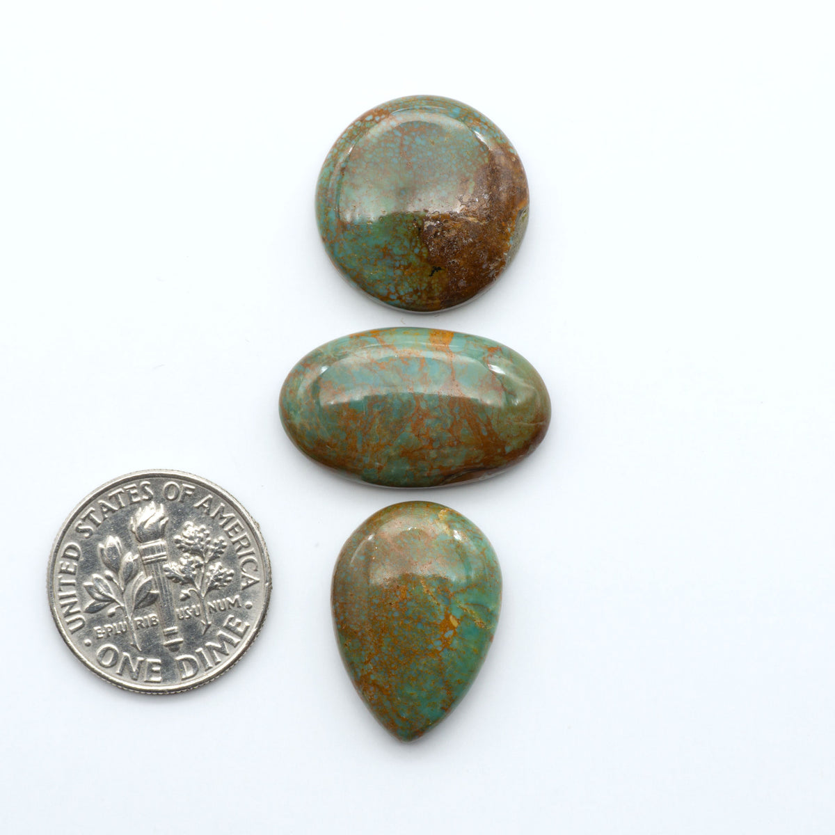 Turquoise Mountain Turquoise cabochons, polished blue and green gemstones with natural matrix on a white background with a US dime for scale