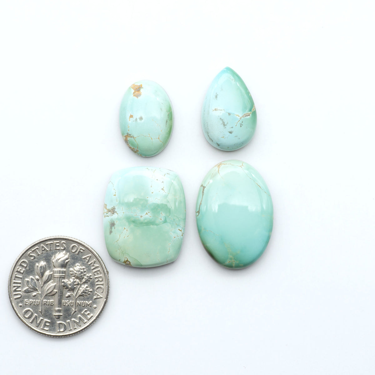 Royston Turquoise cabochons, blue-green color with natural matrix, polished stones on a white background, with a US dime for scale