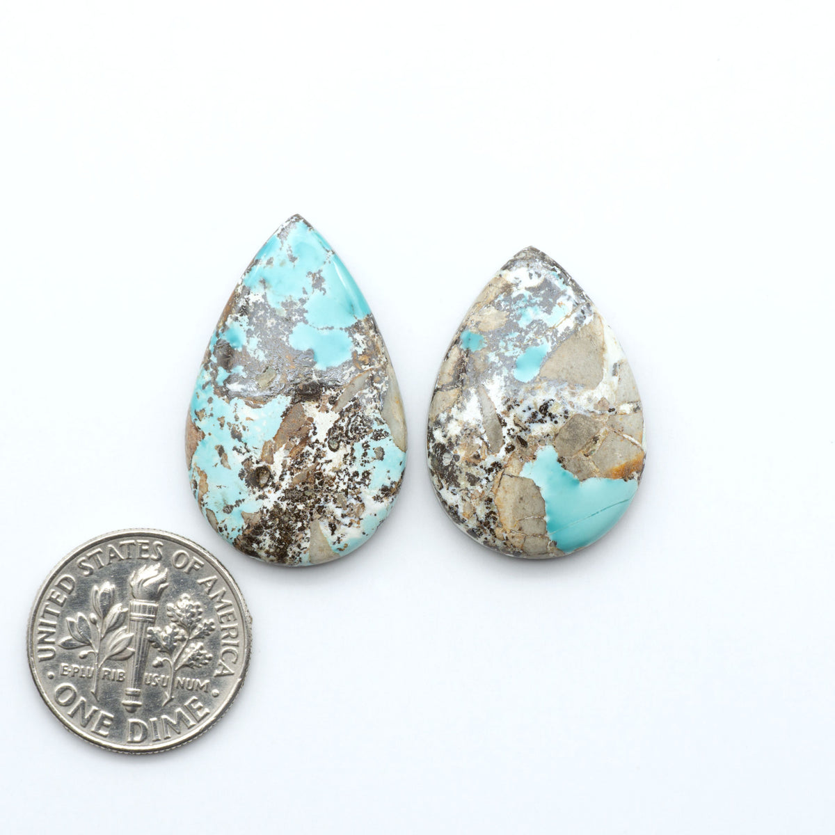 Royston Turquoise cabochons, blue-green color with natural matrix, polished stones on a white background, with a US dime for scale