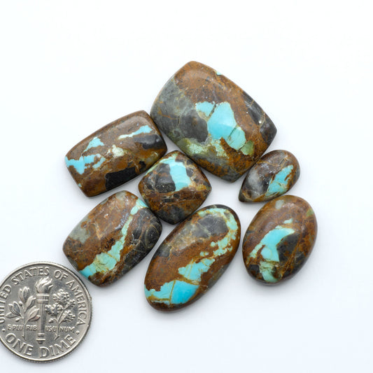 Number 8 Turquoise cabochons, blue and green color with brown matrix, polished stones on a white background, with a US dime for scale