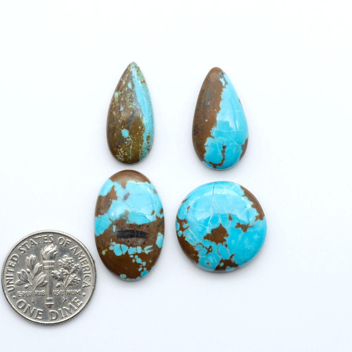 Number 8 Turquoise cabochons, blue and green color with brown matrix, polished stones on a white background, with a US dime for scale