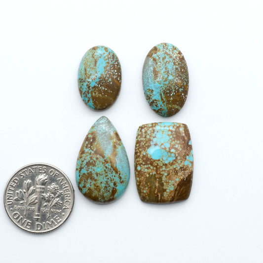 Number 8 Turquoise cabochons, blue and green color with brown matrix, polished stones on a white background, with a US dime for scale