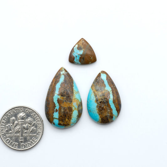 Number 8 Turquoise cabochons, blue and green color with brown matrix, polished stones on a white background, with a US dime for scale