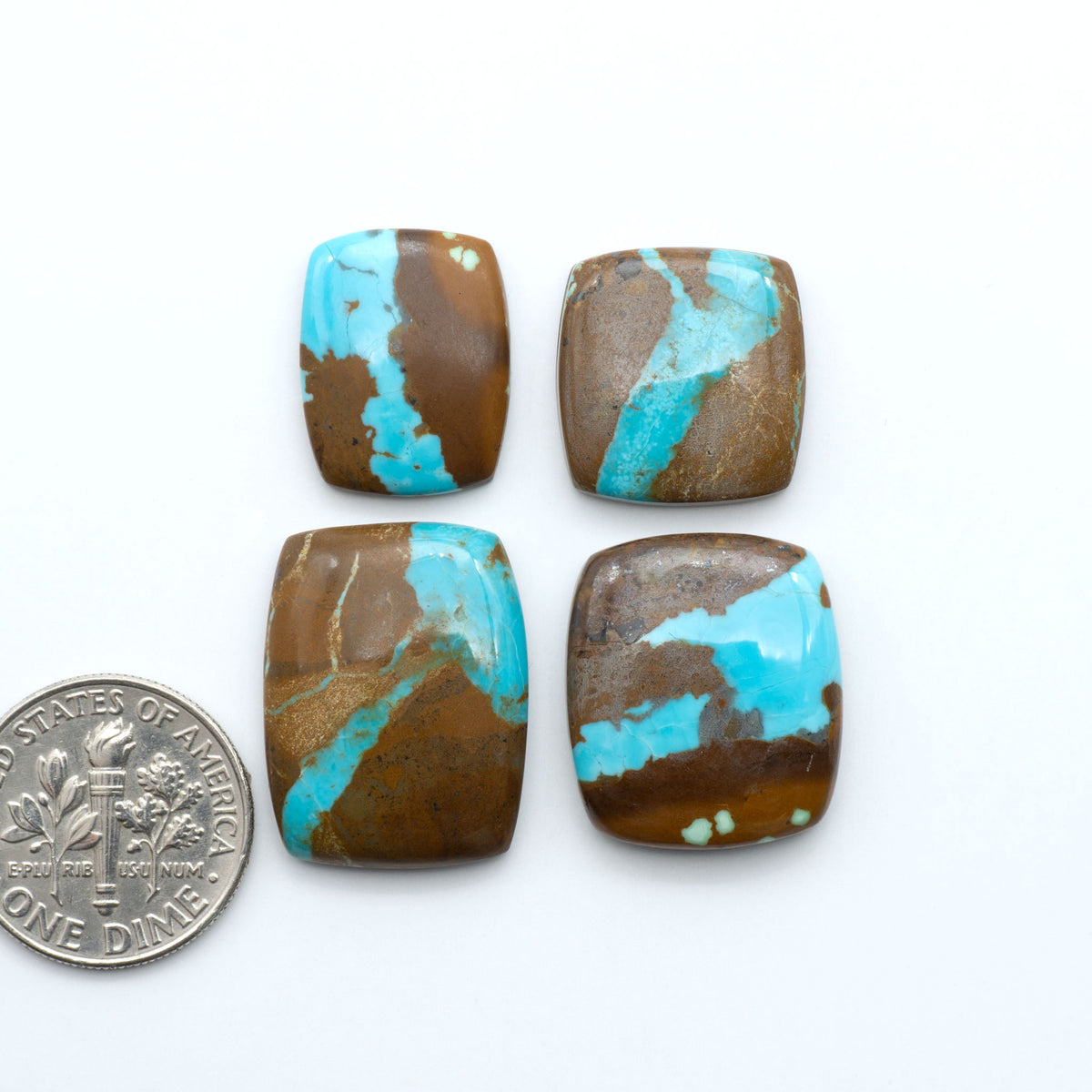 Number 8 Turquoise cabochons, blue and green color with brown matrix, polished stones on a white background, with a US dime for scale