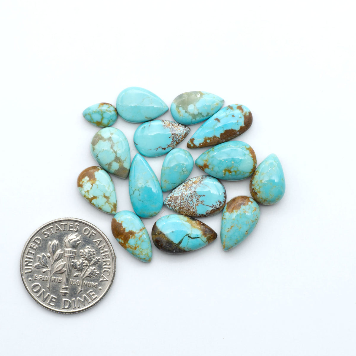 Number 8 Turquoise cabochons, blue and green color with brown matrix, polished stones on a white background, with a US dime for scale