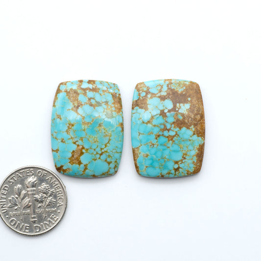 Number 8 Turquoise cabochons, blue and green color with brown matrix, polished stones on a white background, with a US dime for scale