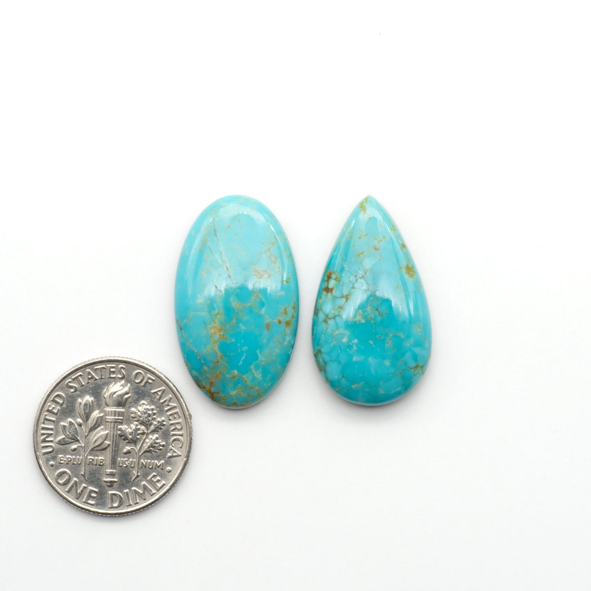 Number 8 Turquoise cabochons, blue and green color with brown matrix, polished stones on a white background, with a US dime for scale