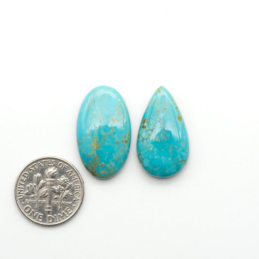 Number 8 Turquoise cabochons, blue and green color with brown matrix, polished stones on a white background, with a US dime for scale