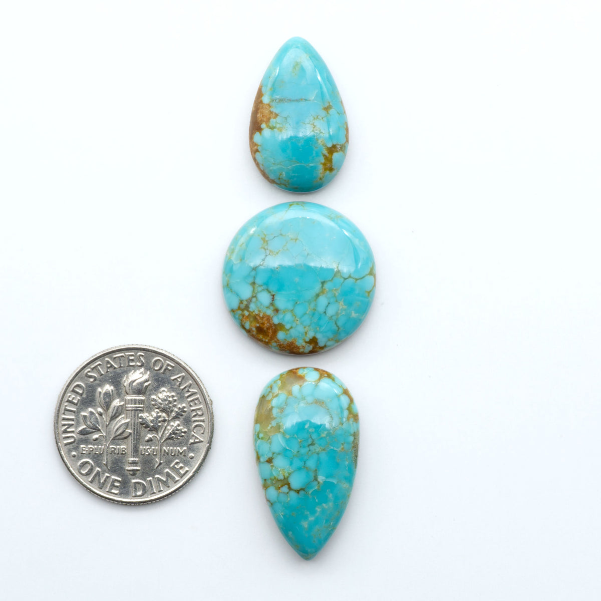 Number 8 Turquoise cabochons, blue and green color with brown matrix, polished stones on a white background, with a US dime for scale
