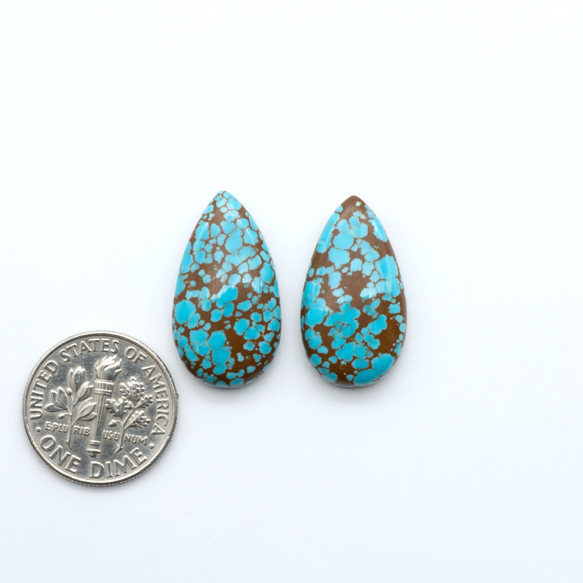Number 8 Turquoise cabochons, blue and green color with brown matrix, polished stones on a white background, with a US dime for scale