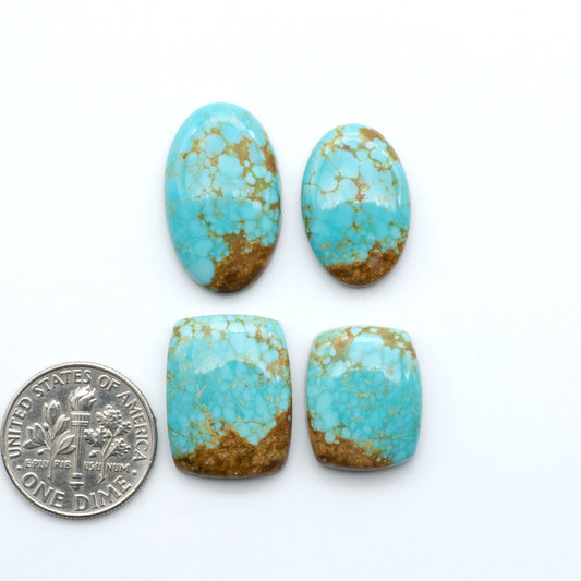 Number 8 Turquoise cabochons, blue and green color with brown matrix, polished stones on a white background, with a US dime for scale